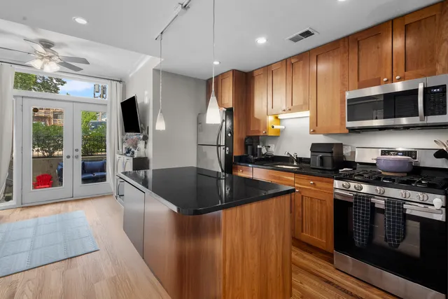 a kitchen with stainless steel appliances granite countertop a sink a stove and a refrigerator