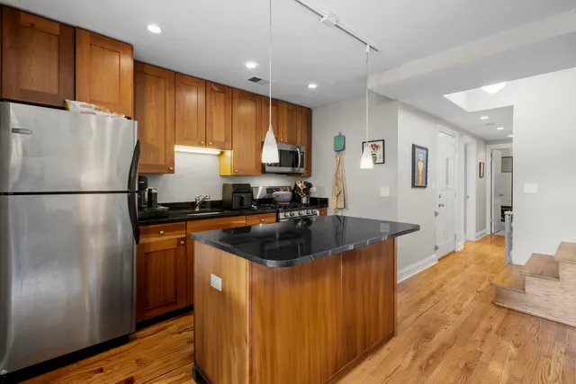 a kitchen with a refrigerator a sink and wooden cabinets