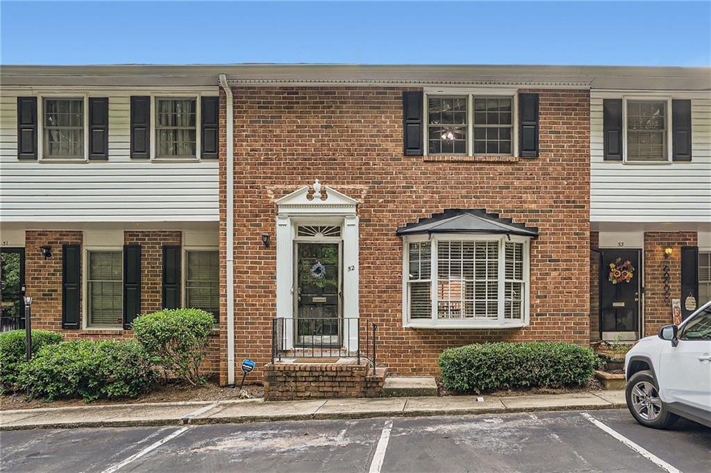 6520 Roswell Road, Unit 52 Atlanta, GA 30328 - Photo 1 of 1 a view of a brick house with a yard and large windows