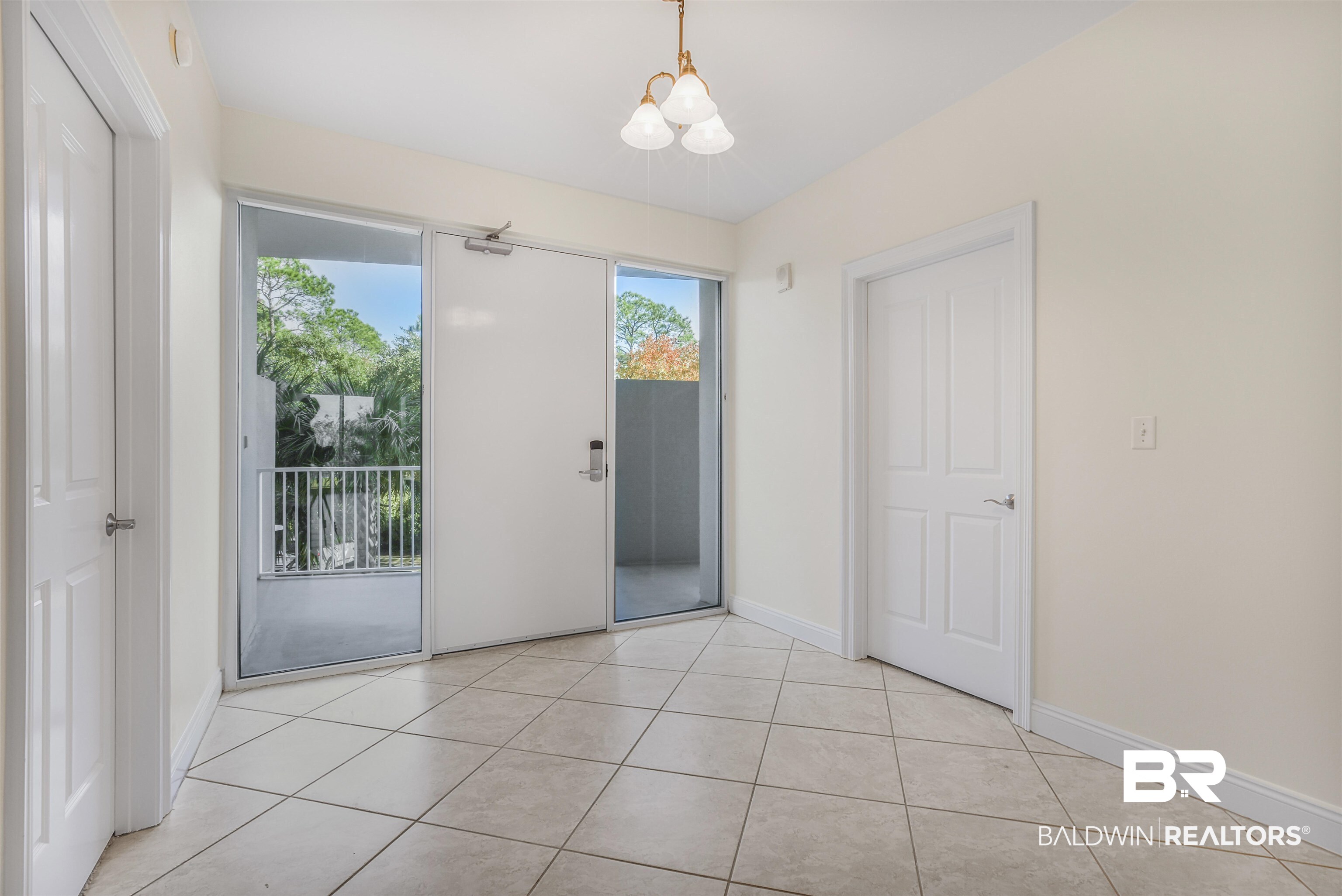 28250 Canal Road, Unit 106 Orange Beach, AL 36561 - Photo 2 of 50 Spare room with a chandelier, healthy amount of natural light, and light tile patterned floors
