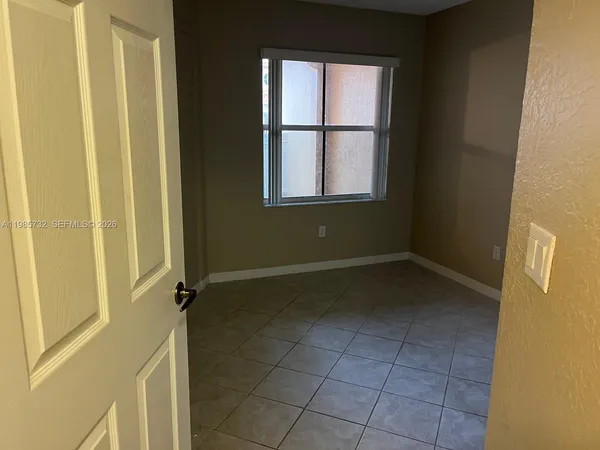an empty room with wooden floor and entrance