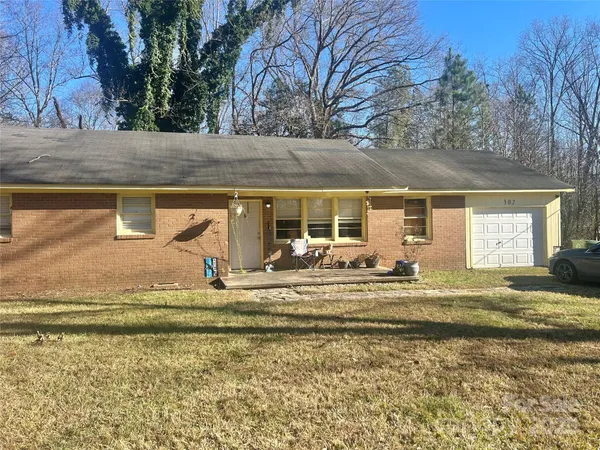 a view of a house with a yard and sitting area
