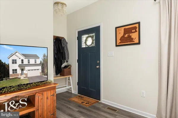 a view of a hallway with wooden floor and entryway