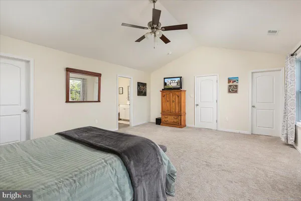 a spacious bedroom with a bed and a chandelier