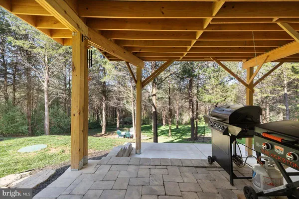a backyard of a house with barbeque oven table and chairs