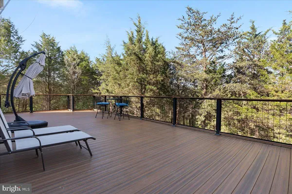 a balcony with wooden floor table and chairs