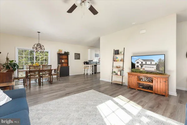 a view of a living room a dining room wooden floor and a rug