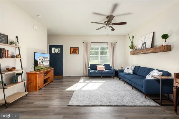 a living room with furniture and a wooden floor