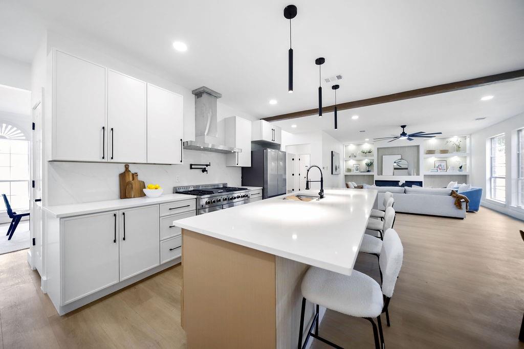 a kitchen with white cabinets and chairs
