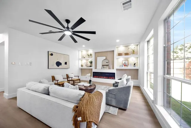 a kitchen with stainless steel appliances kitchen island granite countertop a table chairs refrigerator and microwave