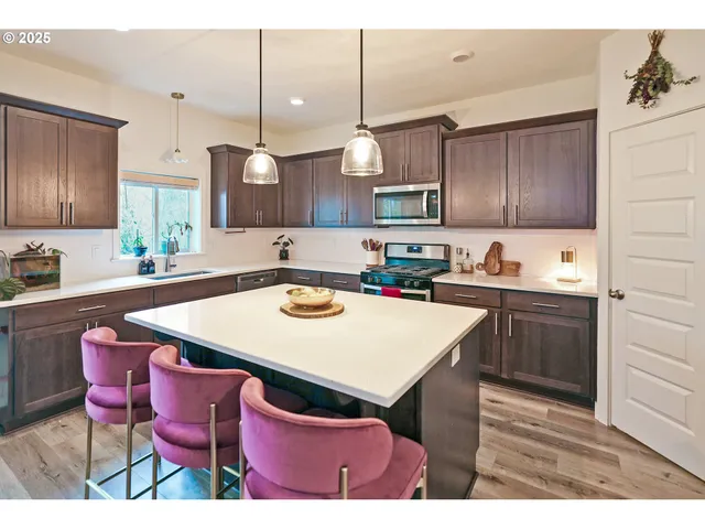 a kitchen with a dining table chairs and white cabinets