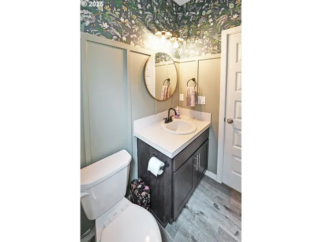 a bathroom with a toilet sink vanity and mirror