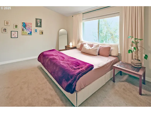 a bedroom with a bed and a large window