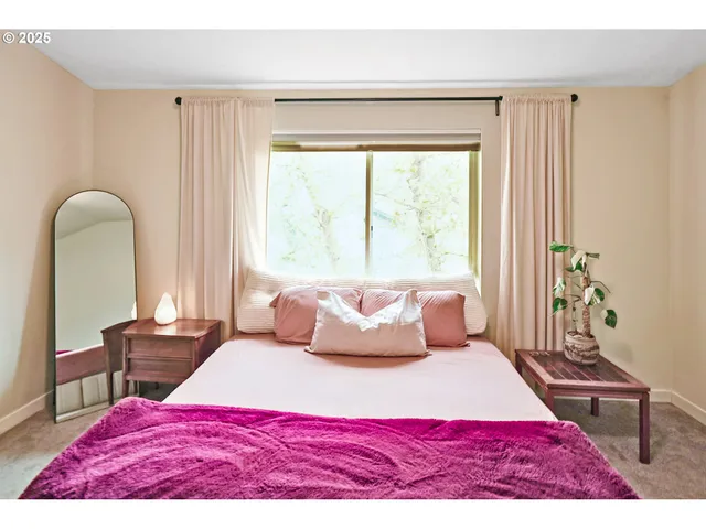 a bedroom with a bed a table and a large mirror