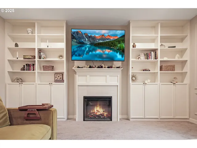 a living room with a furniture a flat screen tv and a fireplace