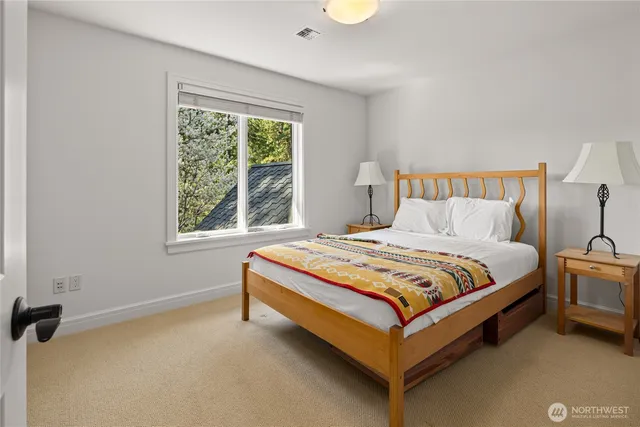 a bed sitting in a bedroom next to a window