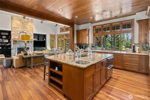 a kitchen with stainless steel appliances granite countertop a sink stove and wooden floor
