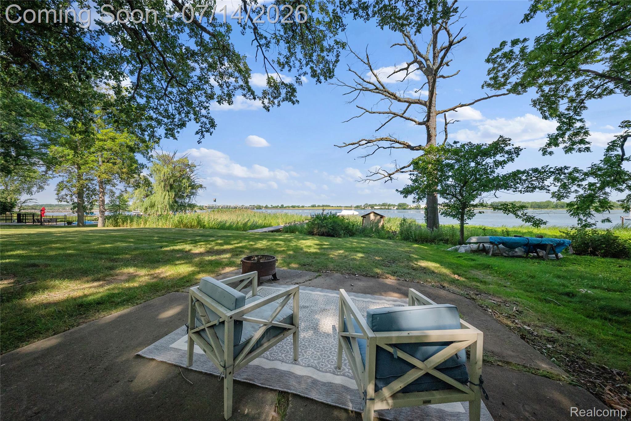 18460 Meridian Road Grosse Ile, MI 48138 - Photo 43 of 50 Expansive waterside property featuring a concrete patio, mature trees, and a spacious lawn extending to the water's edge