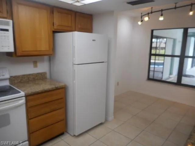 a kitchen with a refrigerator sink and cabinets