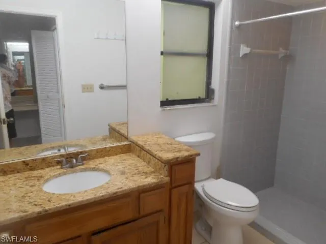a bathroom with a granite countertop toilet sink and mirror