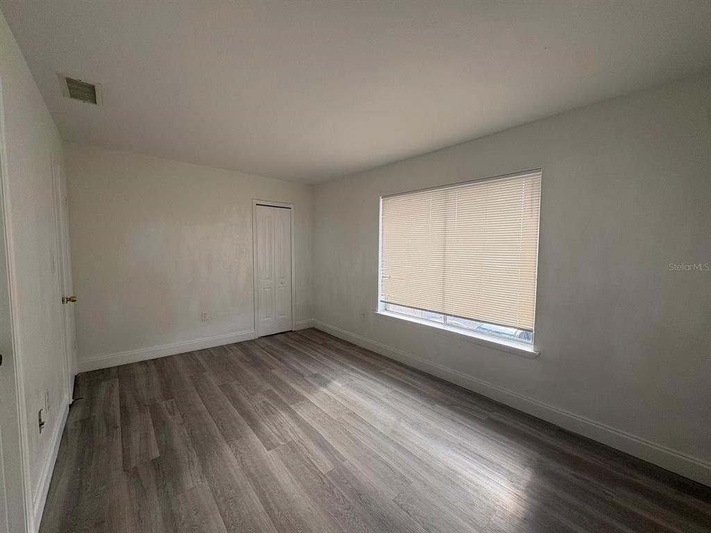 4033 Henley Road, Unit 1707 Orlando, FL 32839 - Photo 51 of 66 an empty room with wooden floor and windows
