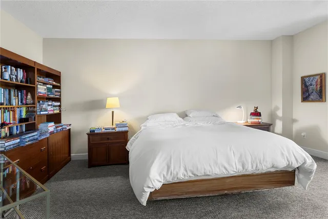 a bed sitting in a bedroom and a book shelf