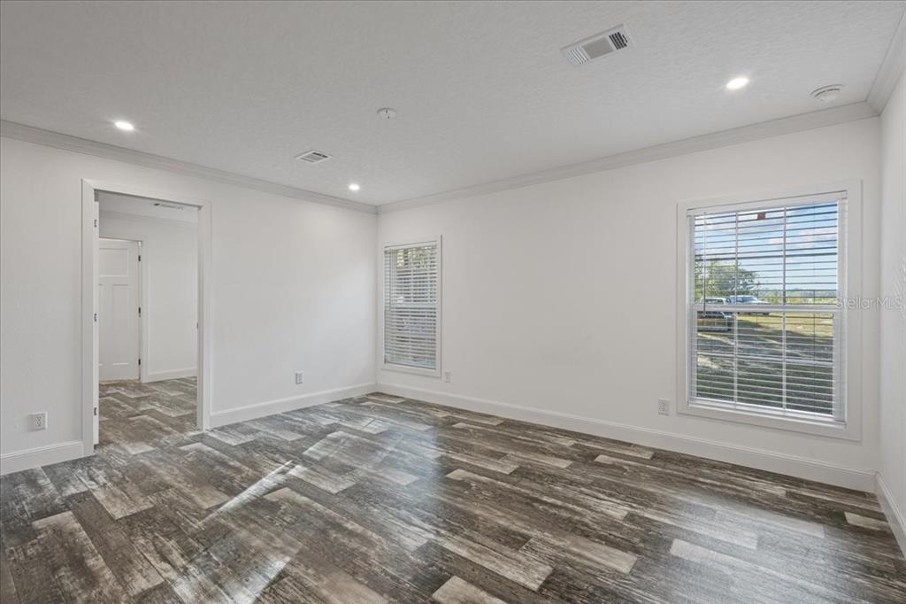 4654 Northwest 45th Avenue Bell, FL 32619 - Photo 12 of 52 a view of an empty room with wooden floor and a window