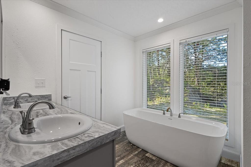 4654 Northwest 45th Avenue Bell, FL 32619 - Photo 19 of 52 a bathroom with a tub a sink and a window