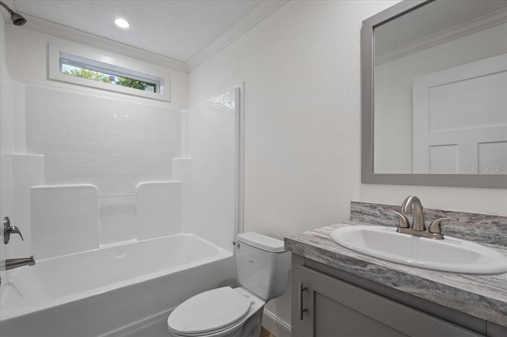 4654 Northwest 45th Avenue Bell, FL 32619 - Photo 25 of 52 a bathroom with a granite countertop sink toilet and shower