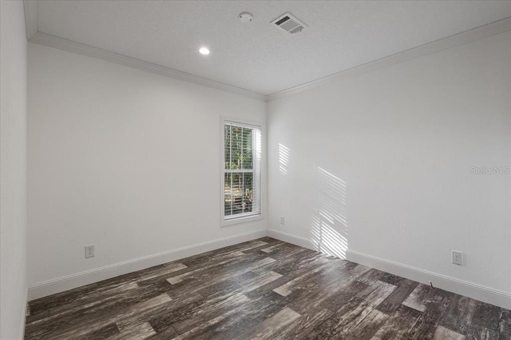 4654 Northwest 45th Avenue Bell, FL 32619 - Photo 27 of 52 an empty room with wooden floor and windows