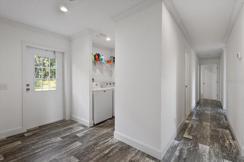 4654 Northwest 45th Avenue Bell, FL 32619 - Photo 32 of 52 a view of a hallway with wooden floor and a bathroom