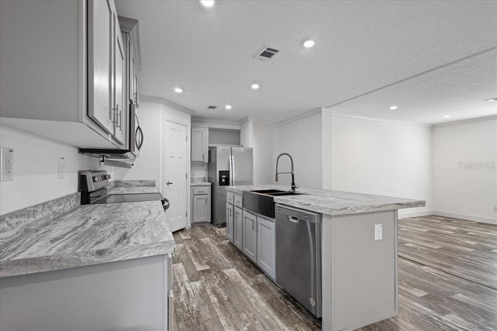 4654 Northwest 45th Avenue Bell, FL 32619 - Photo 9 of 52 a kitchen with stainless steel appliances granite countertop a stove a sink and a refrigerator