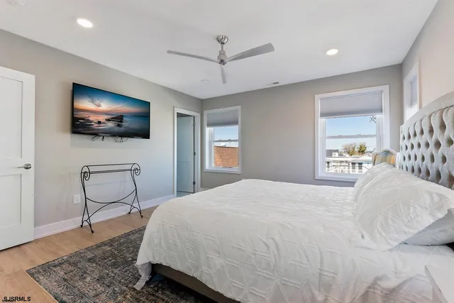 a bedroom with a bed a flat screen tv and a chandelier