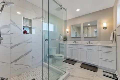 a spacious bathroom with a shower sink and mirror