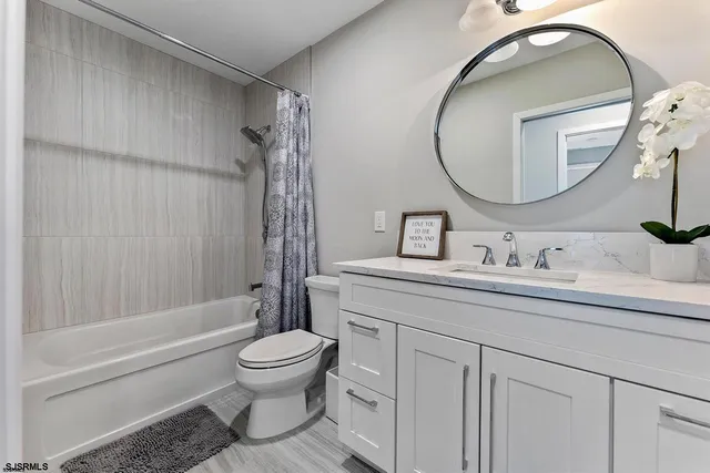 a bathroom with a granite countertop toilet sink and a mirror