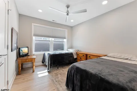 a bedroom with a bed a chandelier and a flat tv screen