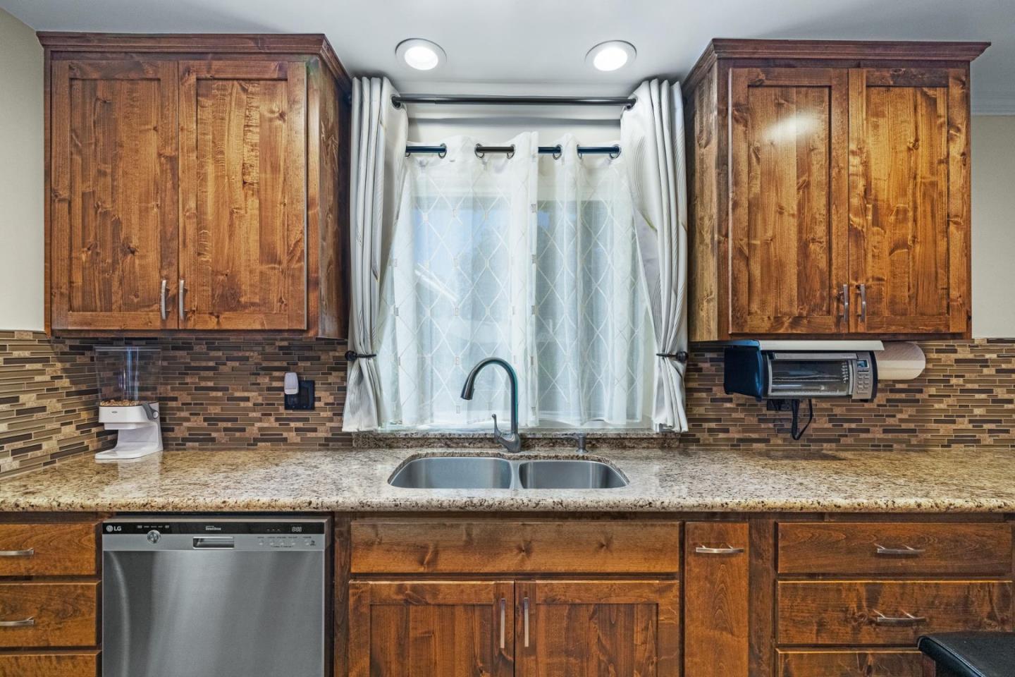 1504 Mable Avenue Modesto, CA 95355 - Photo 20 of 47 a kitchen with granite countertop a sink and a wooden cabinets