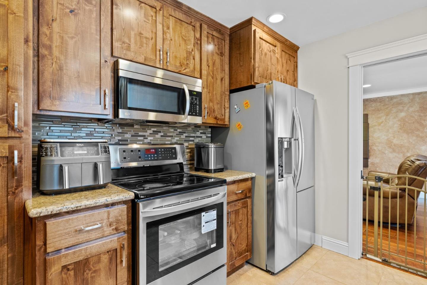 1504 Mable Avenue Modesto, CA 95355 - Photo 6 of 47 a kitchen with stainless steel appliances a stove a microwave and a refrigerator