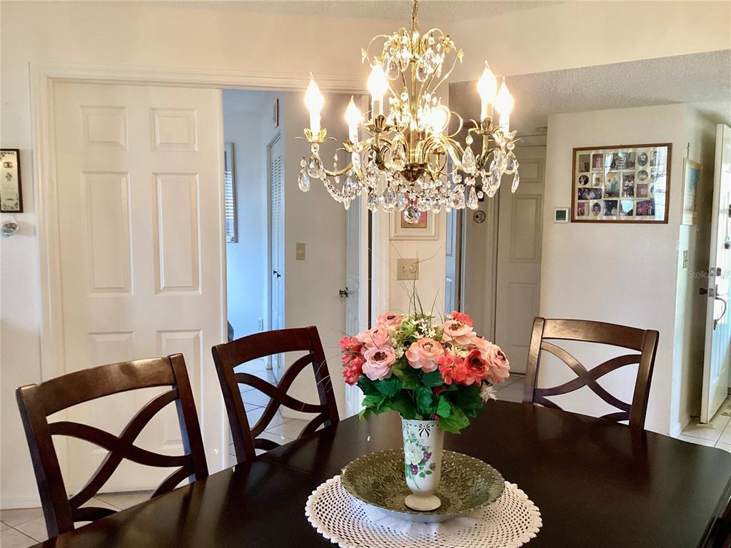 4529 Whitton Way, Unit 214 New Port Richey, FL 34653 - Photo 14 of 45 a dining room with furniture and chandelier