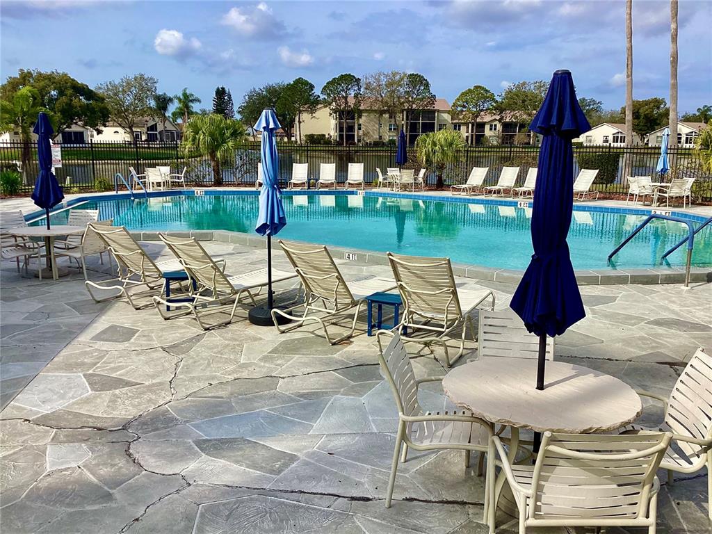 4529 Whitton Way, Unit 214 New Port Richey, FL 34653 - Photo 34 of 45 a view of a swimming pool with a patio and a garden