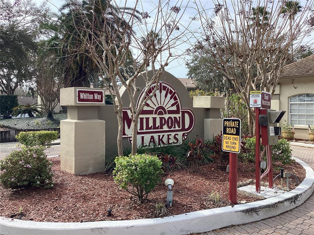4529 Whitton Way, Unit 214 New Port Richey, FL 34653 - Photo 43 of 45 a sign board with a bench and trees