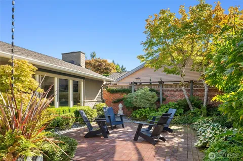 a backyard of a house with table and chairs and potted plants
