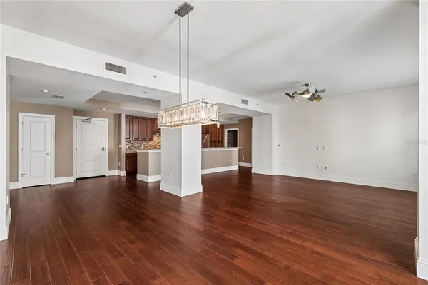 a living room with furniture a chandelier and a flat screen tv