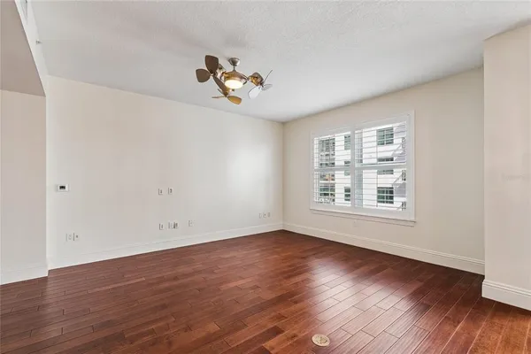 an empty room with wooden floor and windows