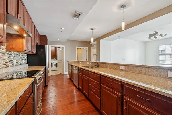 a kitchen with stainless steel appliances granite countertop a sink stove and cabinets