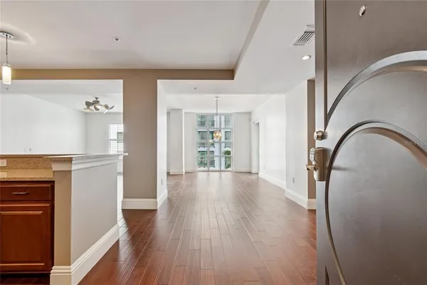 a view of an empty room with a window and wooden floor