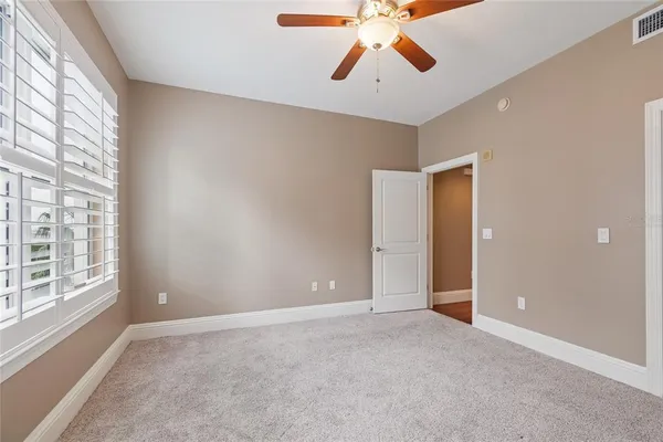 an empty room with windows and fan