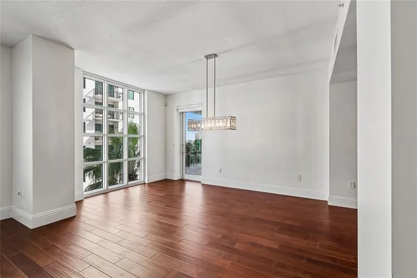a view of an empty room with window and wooden floor