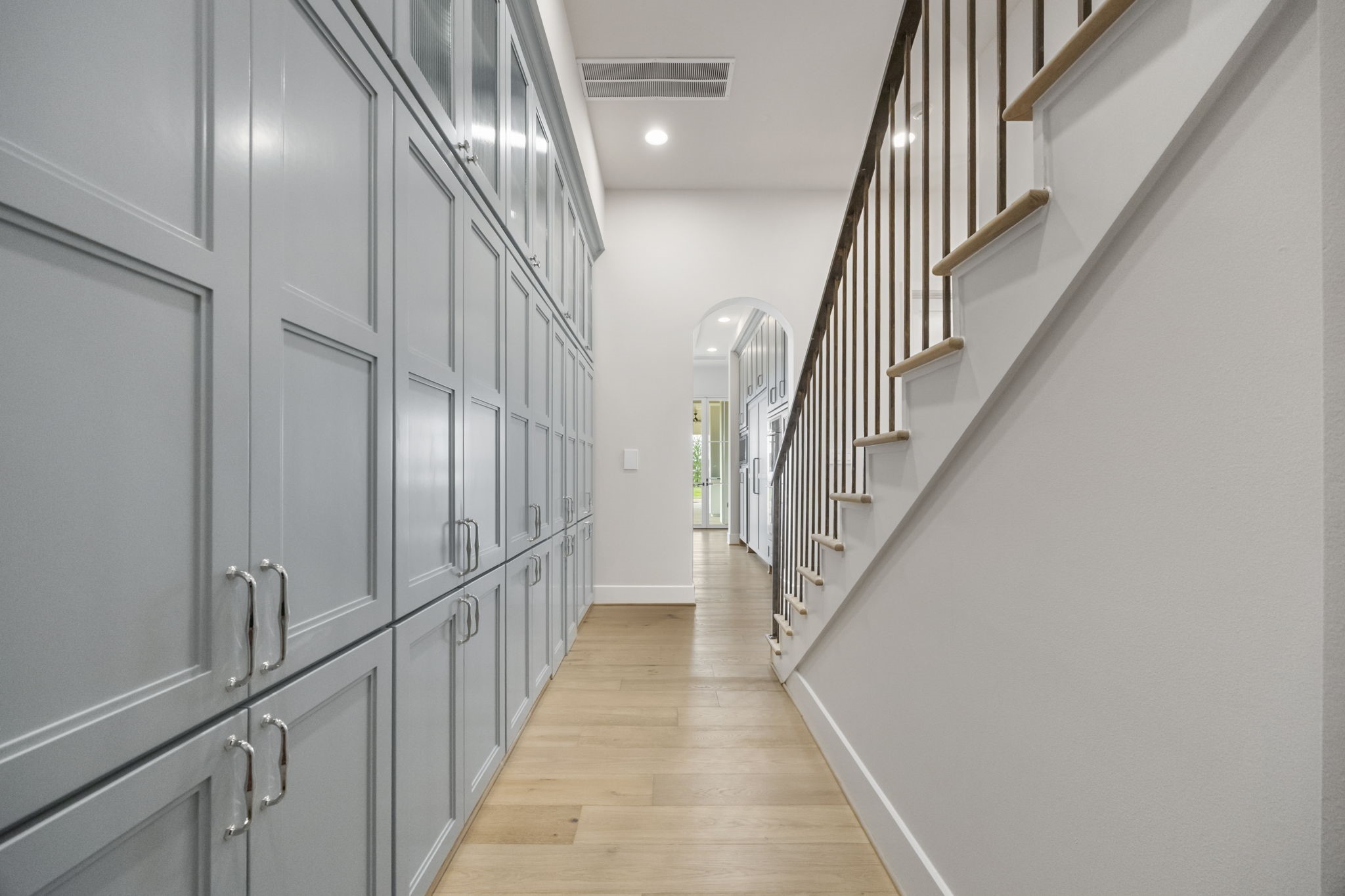 4233 Two Gun Way Katy, TX 77494 - Photo 13 of 47 Walk out of your stunning kitchen to rear hall staircase and a large wall of storage cabinets in front of your walk-in panty.
