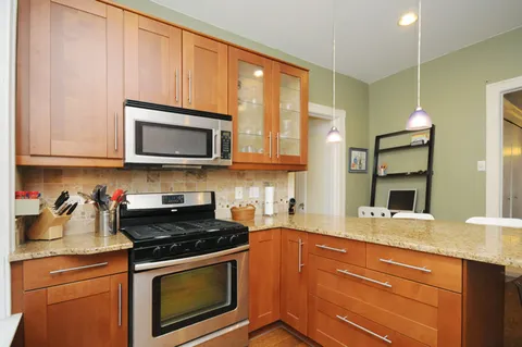 a kitchen with stainless steel appliances granite countertop a stove microwave and cabinets
